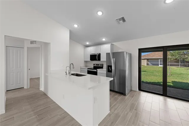 a view of a kitchen with refrigerator stove microwave and cabinets