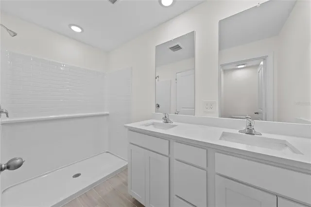 a bathroom with a sink double vanity and tub