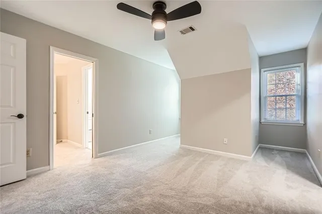 an empty room with windows and ceiling fan view