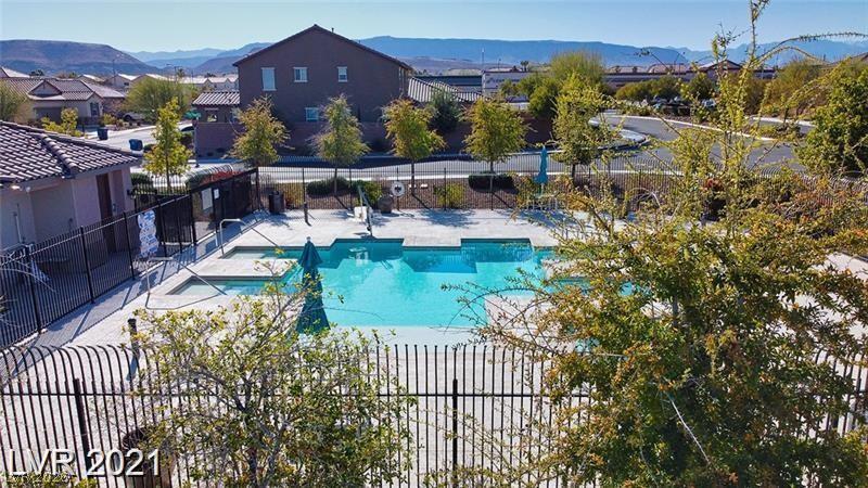5475 Ordesa Valley Road Las Vegas, NV 89148 - Photo 3 of 35 An inviting community pool surrounded by mature trees offers a refreshing escape with mountain views.