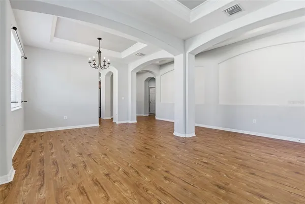 a view of a room with wooden floor and chandelier
