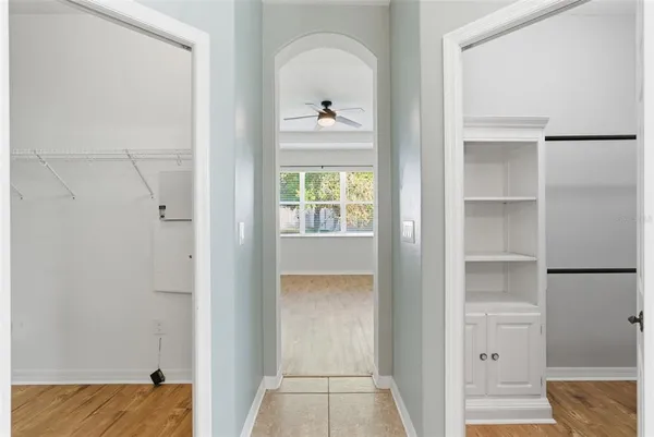 a walk in closet with wooden floor