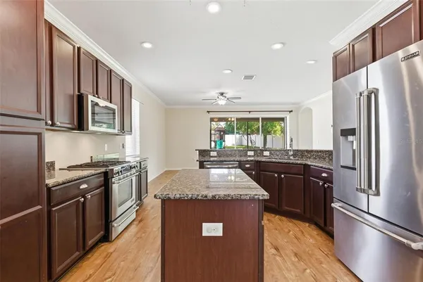 a kitchen with stainless steel appliances granite countertop a sink stove and refrigerator