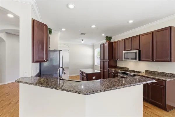 a kitchen with kitchen island granite countertop a sink and a counter top space
