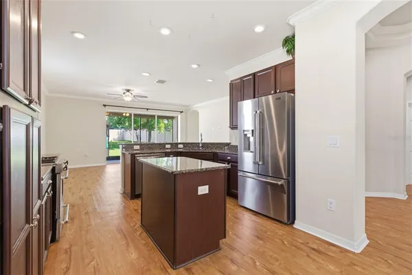 a kitchen with stainless steel appliances granite countertop a refrigerator a stove and a wooden floors
