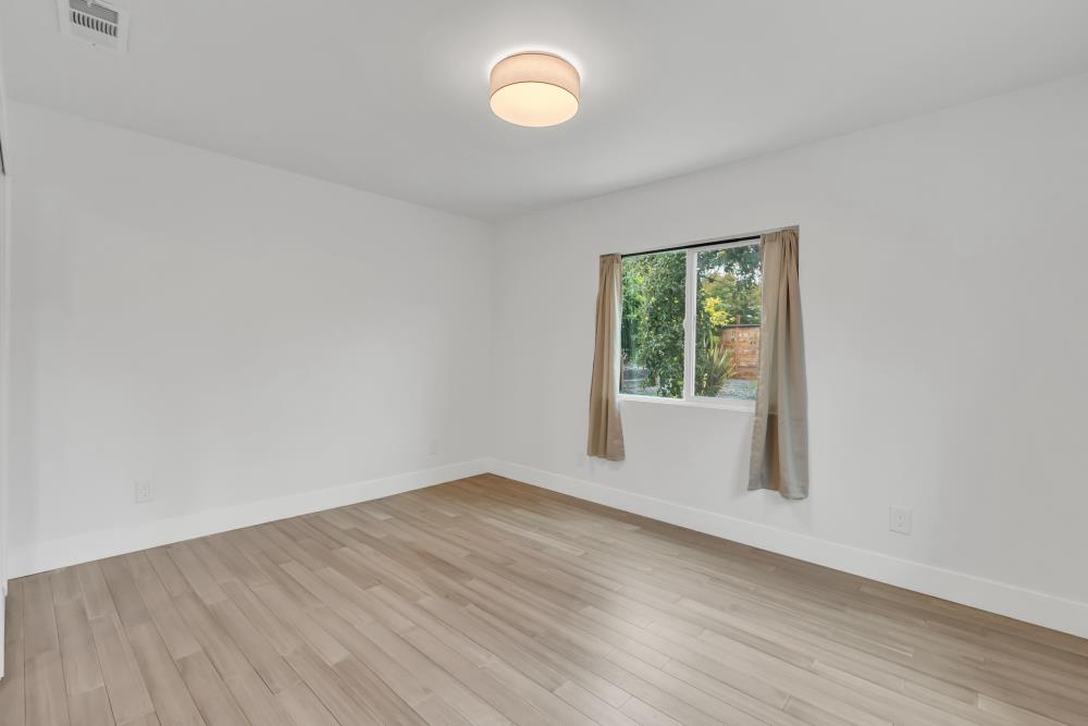 2437 Acton Street Berkeley, CA 94702 - Photo 26 of 54 an empty room with wooden floor and windows