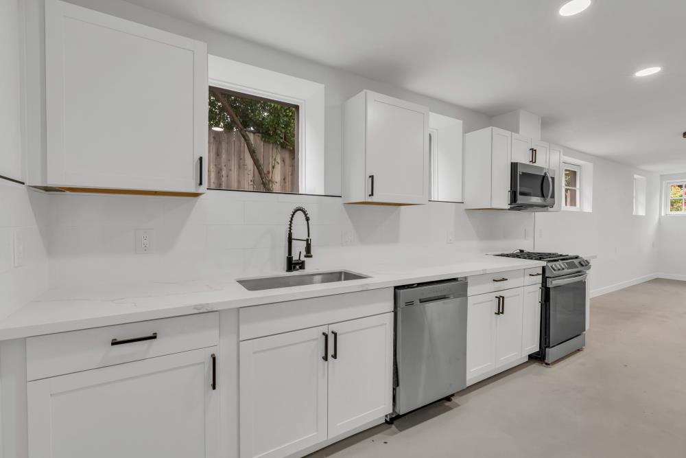 2437 Acton Street Berkeley, CA 94702 - Photo 45 of 54 a kitchen with white cabinets and sink
