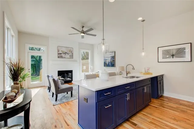 a kitchen with a stove a sink and a refrigerator with wooden floor