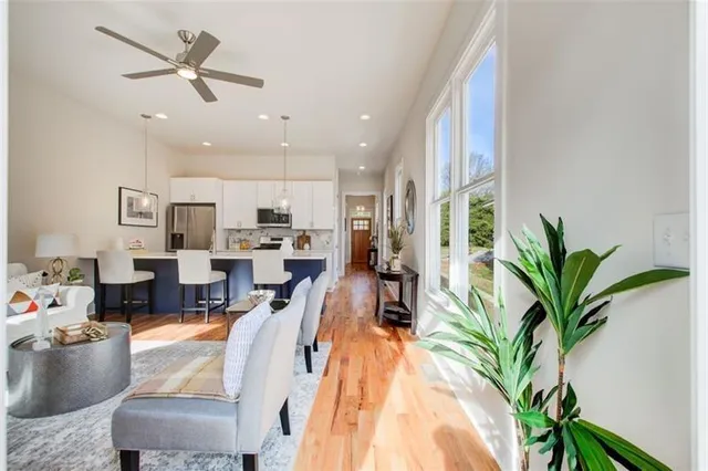 a living room with furniture kitchen view and a potted plant
