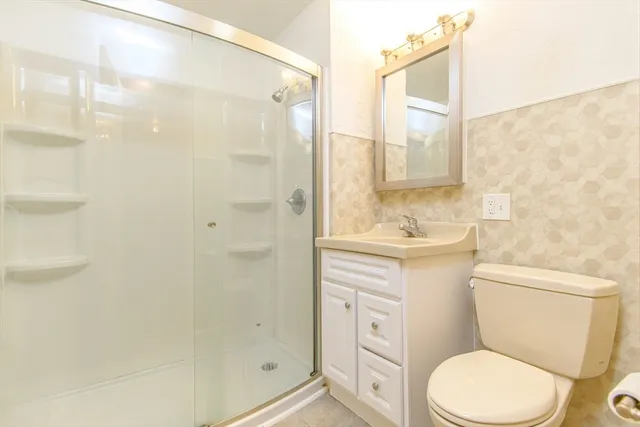 a bathroom with a sink a toilet and shower