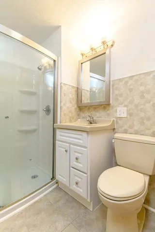 a bathroom with a granite countertop toilet a sink and shower