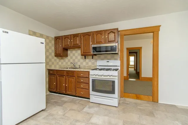 a kitchen with stainless steel appliances granite countertop a refrigerator and a stove