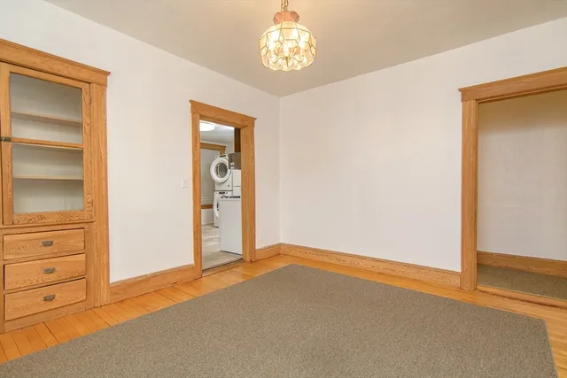 an empty room with closet and windows