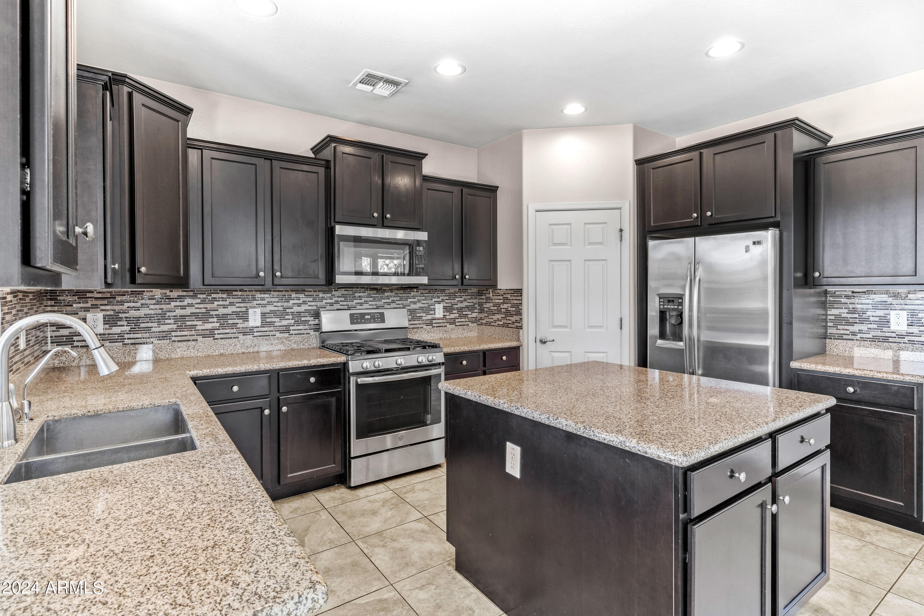 5515 West Hackamore Drive Phoenix, AZ 85083 - Photo 4 of 35 a kitchen with stainless steel appliances granite countertop a sink stove and refrigerator