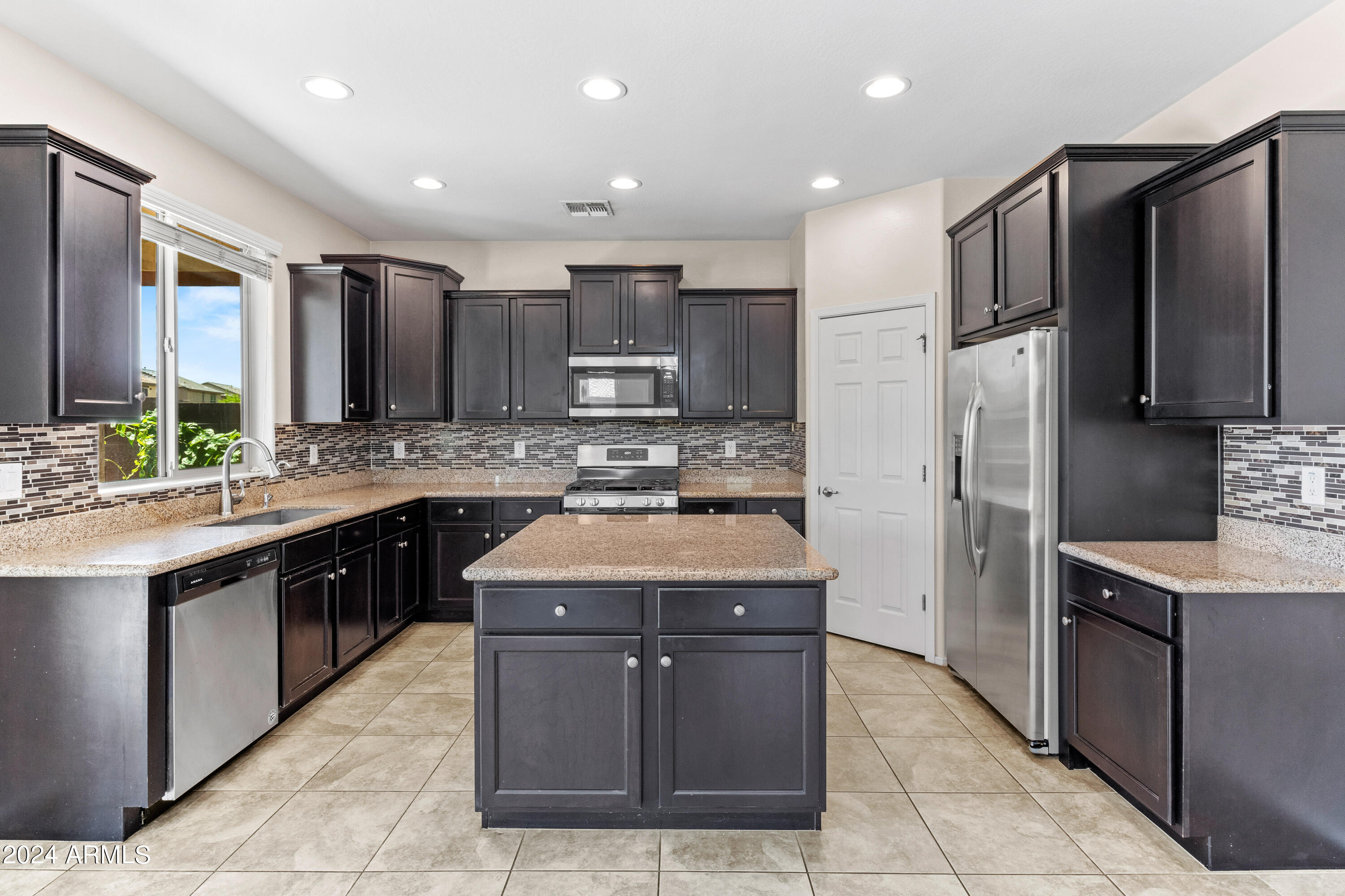 5515 West Hackamore Drive Phoenix, AZ 85083 - Photo 5 of 35 a kitchen with stainless steel appliances granite countertop a stove refrigerator and a sink