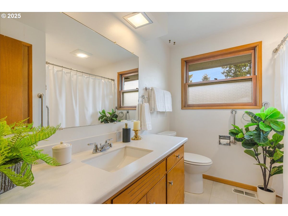 11030 Northeast Davis Street Portland, OR 97220 - Photo 30 of 48 a bathroom with a granite countertop sink a large mirror and a potted plant