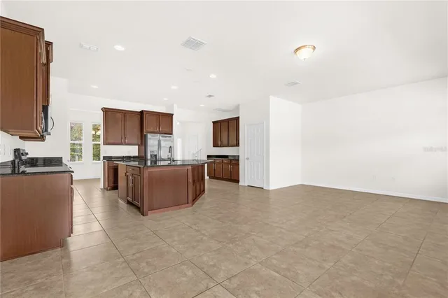 a living room with couches and kitchen view with wooden floor