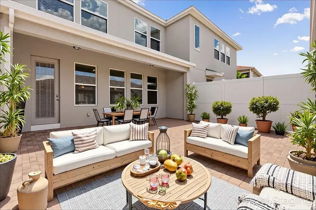 a view of a patio with couches table and chairs with potted plants
