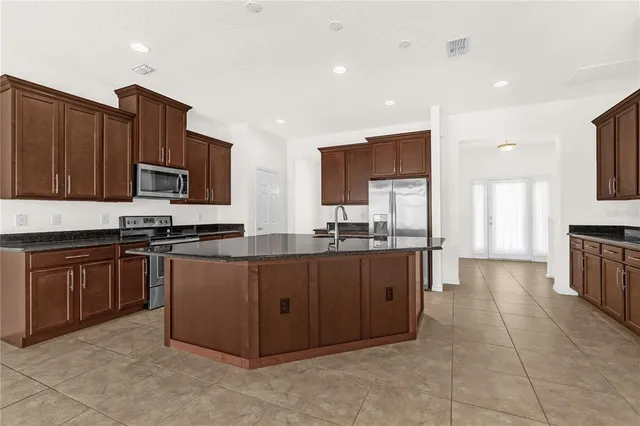 a large kitchen with stainless steel appliances lots of counter top space