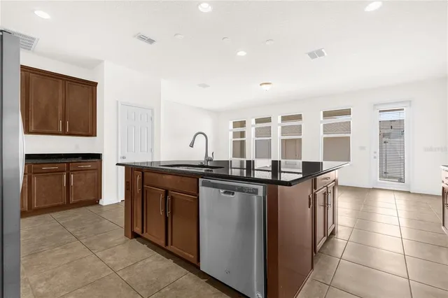 a kitchen with stainless steel appliances granite countertop a stove a sink and a refrigerator