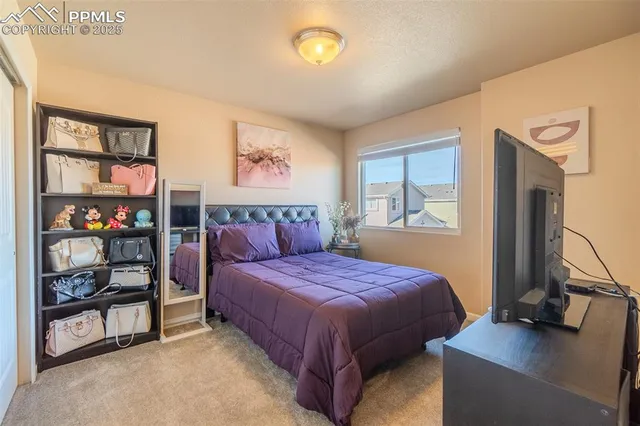 a bedroom with a bed and a painting on the wall