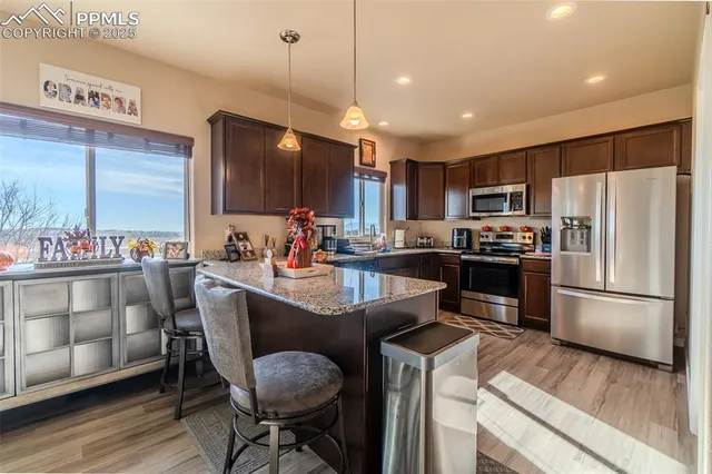 a kitchen with kitchen island a large counter top space appliances and cabinets