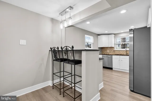 a kitchen with stainless steel appliances a sink cabinets and wooden floor