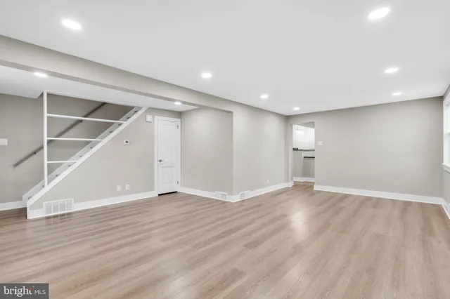 a view of an empty room with wooden floor and closet