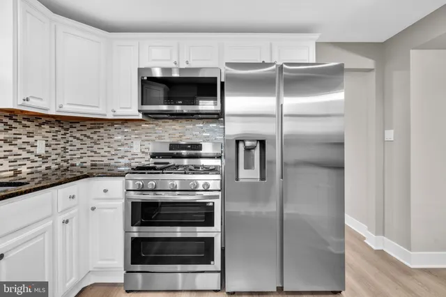 a kitchen with stainless steel appliances granite countertop a stove and a refrigerator