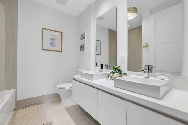 a spacious en suite bathroom with a double vanity sink and a mirror