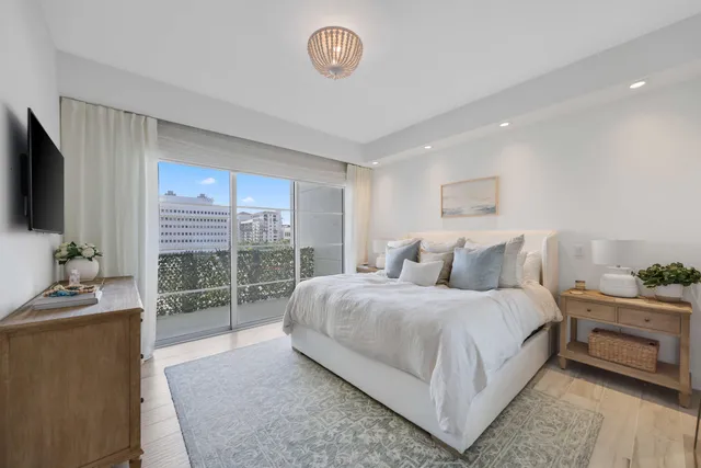 a bedroom with a balcony a bed and a flat screen tv