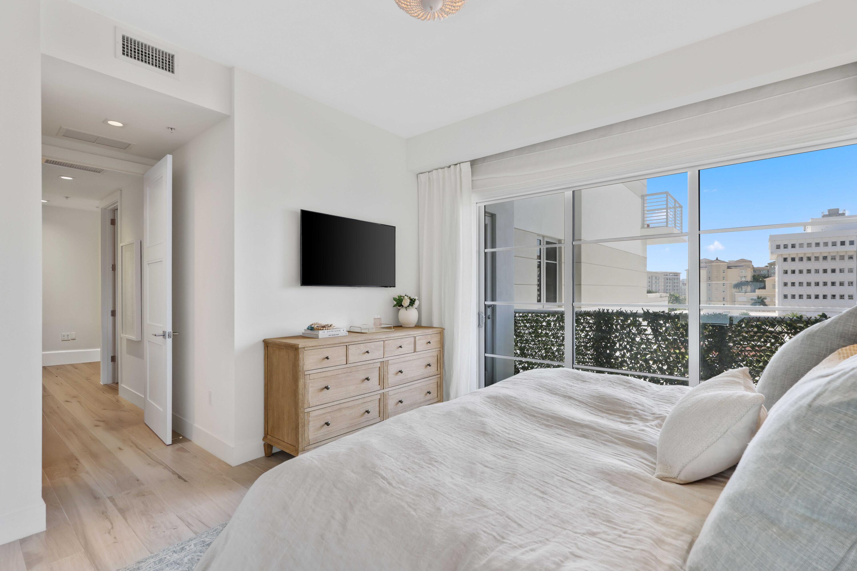 155 East Boca Raton Road, Unit 601 Boca Raton, FL 33432 - Photo 26 of 55 a bedroom with a balcony a bed and a flat screen tv