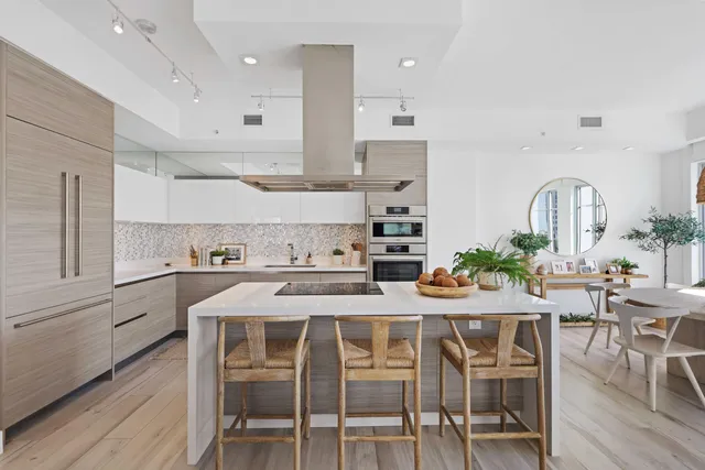 a kitchen with stainless steel appliances kitchen island granite countertop a table and chairs in it