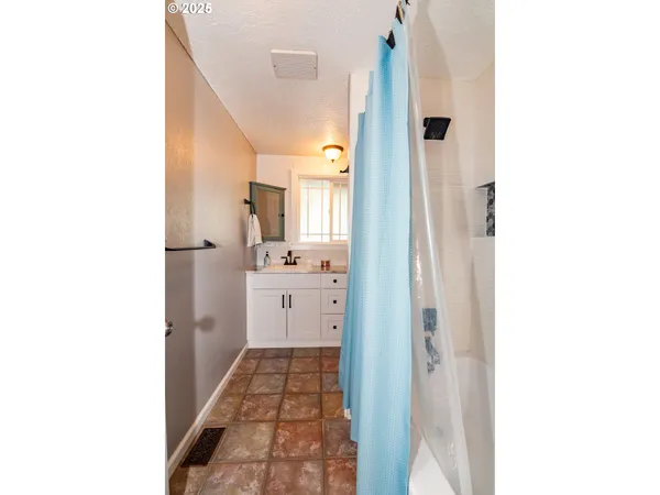 a bathroom with a granite countertop toilet a sink a mirror and a window