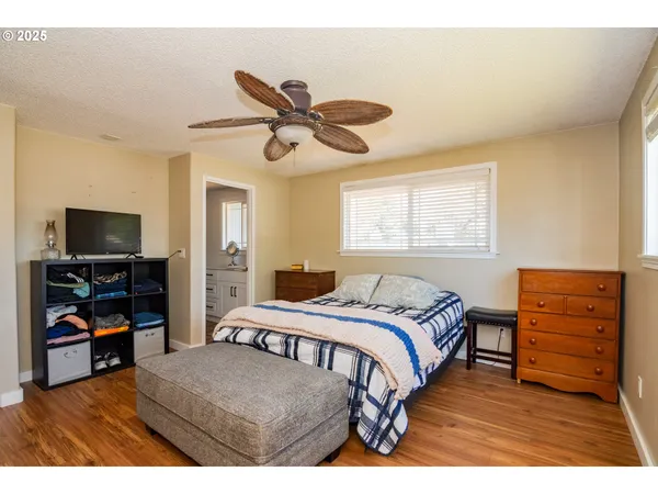a bedroom with a bed and a flat tv screen on dresser