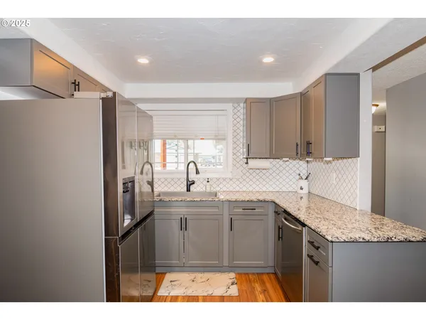 a kitchen with a sink a refrigerator and cabinets