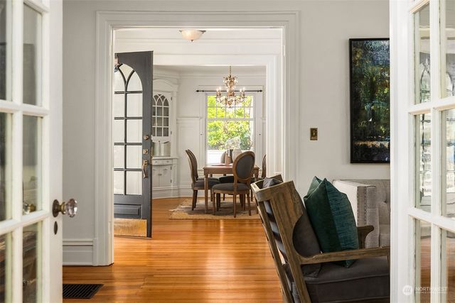 a living room with furniture floor to ceiling window and wooden floor