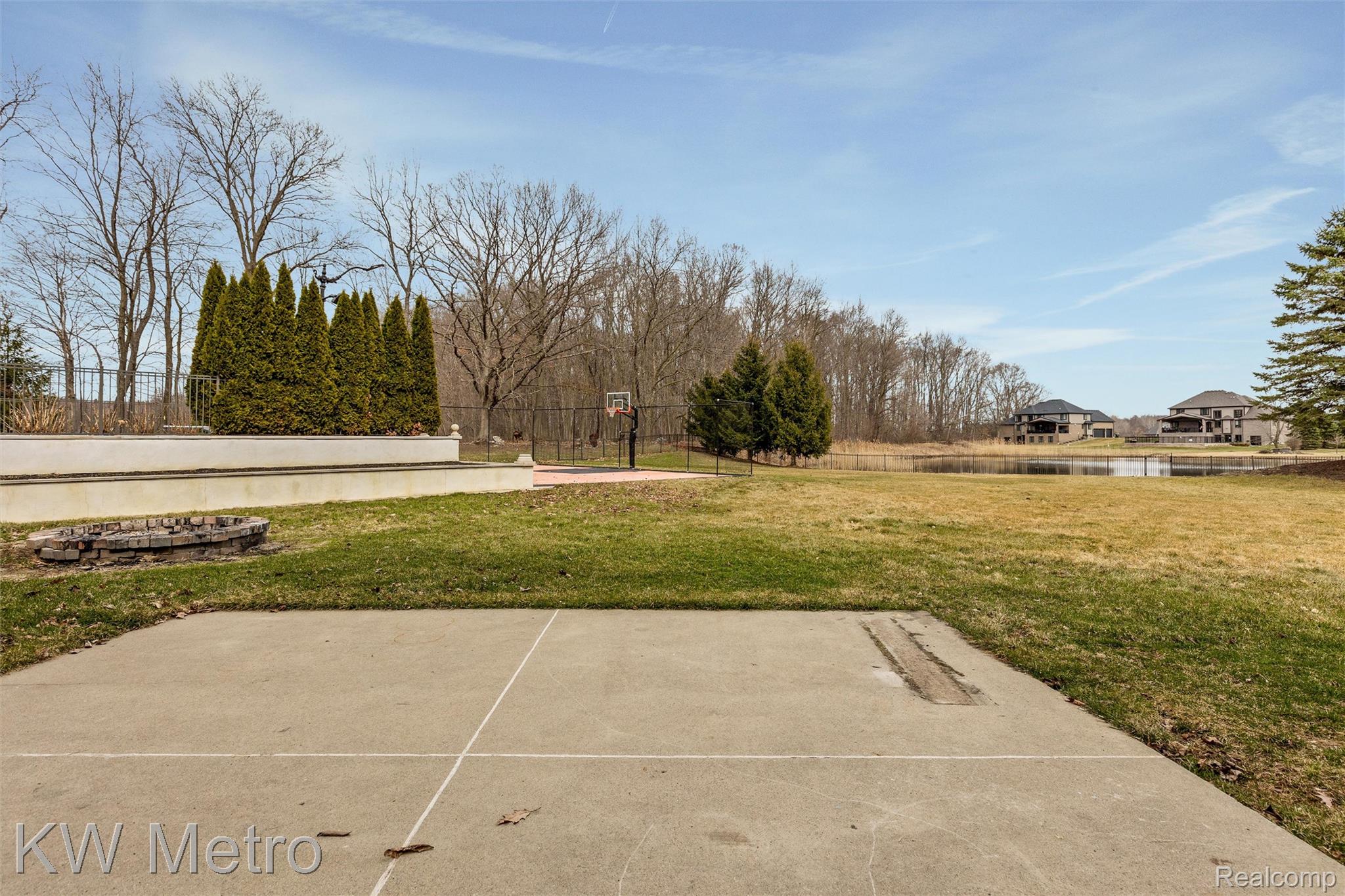 65884 Windrose Court Ray, MI 48096 - Photo 80 of 82 View of patio with an outdoor fire pit and a water view