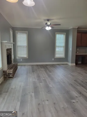 a view of empty room with fireplace and wooden floor