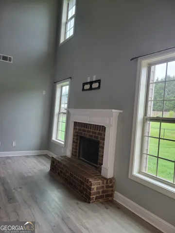 a living room with a fireplace and windows