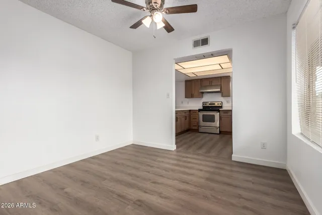 a view of an empty room with wooden floor