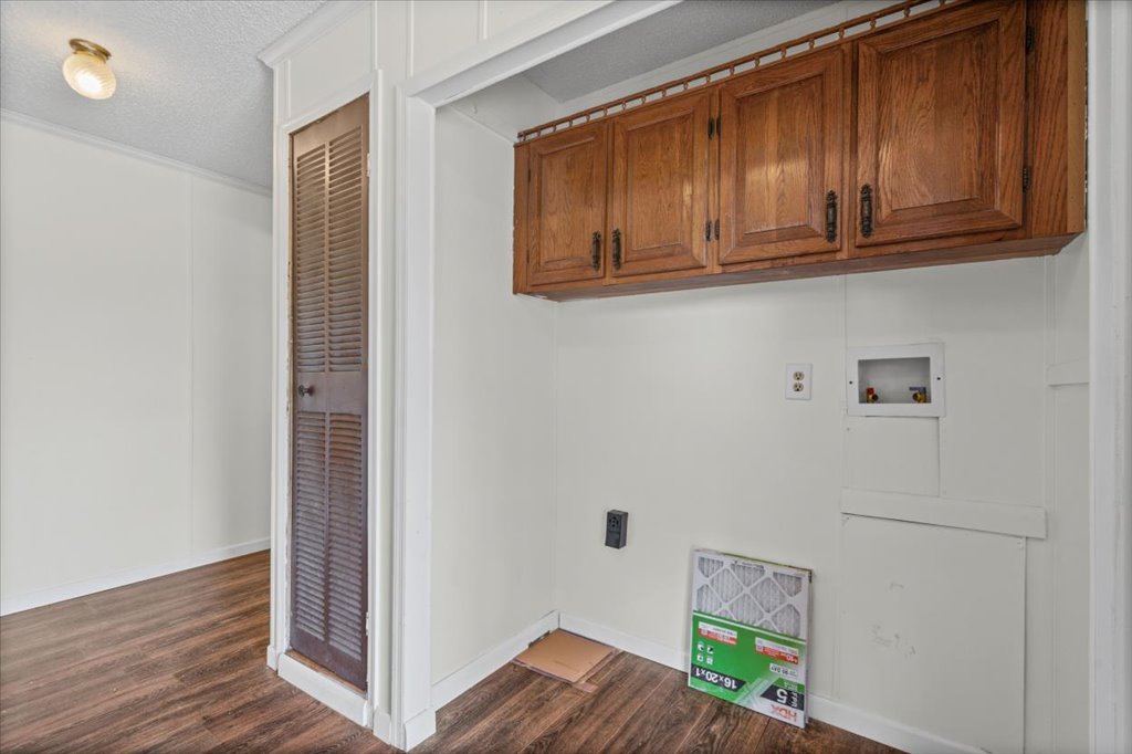 13501 Nutty Brown Road, Unit B Austin, TX 78737 - Photo 21 of 29 Functional utility space with rich wood cabinets offers practical storage and laundry hookups.