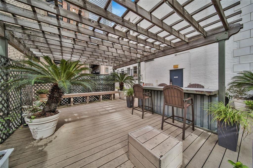 a view of a patio with table and chairs with wooden floor and plants