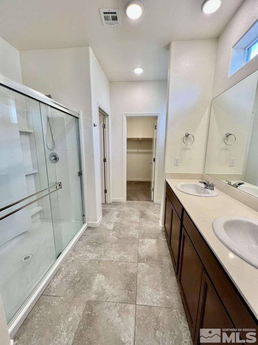 4880 Little Rock Way Sun Valley, NV 89433 - Photo 15 of 30 a bathroom with a double vanity sink mirror double and shower