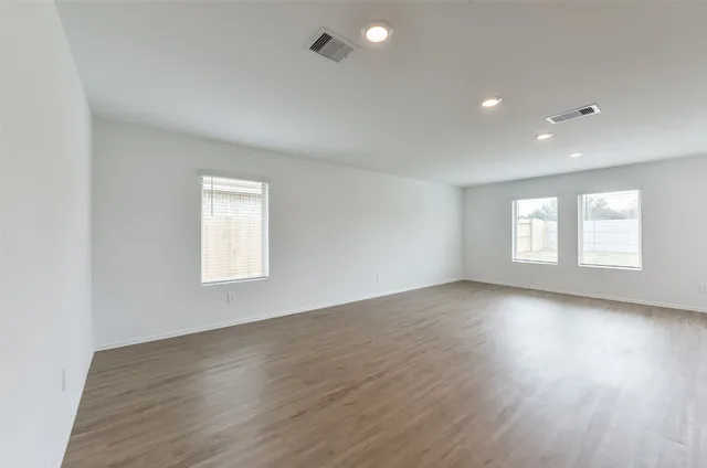 a view of an empty room with wooden floor