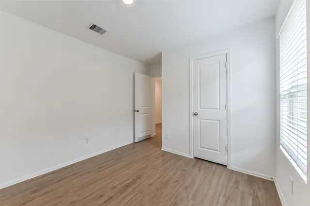 a view of an empty room with wooden floor