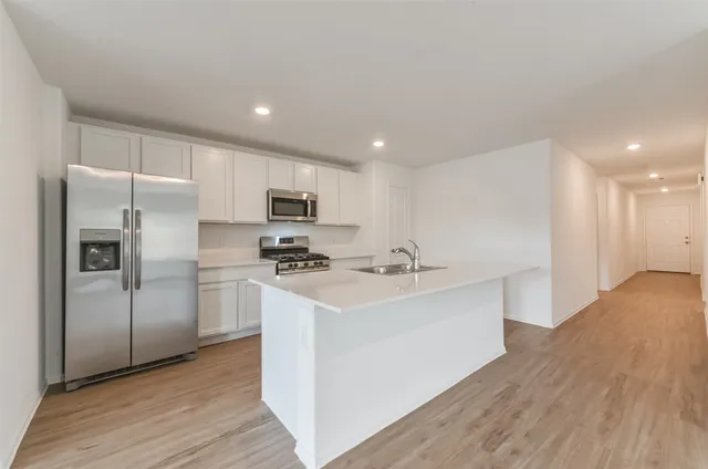 a kitchen with stainless steel appliances a sink stove and refrigerator