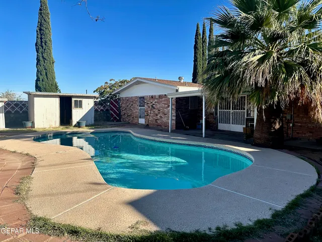 a view of a house with swimming pool and a yard