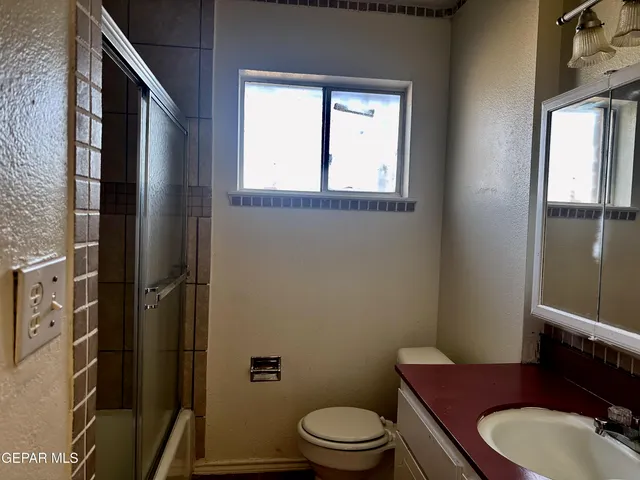 a bathroom with a toilet a sink and mirror