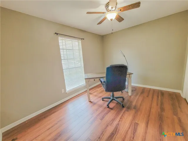 a workspace with wooden floor and a window